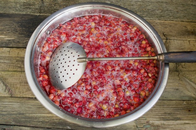 Перекладываем ягоды земляники в кипящий сироп и доводим до кипения