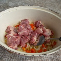 Добавляем свинину в жаровню. На сильном огне обжариваем мясо несколько минут Добавляем свинину в жаровню. На сильном огне обжариваем мясо несколько минут