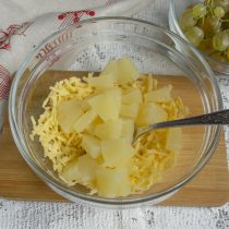 Нарезаем консервированные ананасы мелко, добавляем в салатницу к сыру