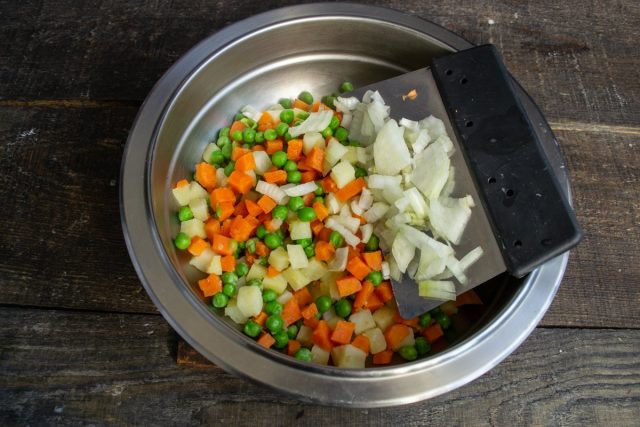 Перекладываем овощи в миску, добавляем мелко порезанную луковицу