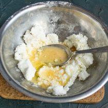 Într-un castron, amestecați brânza de vaci, oul, albușul de ou, un vârf de sare și vanilina pe vârful unui cuțit