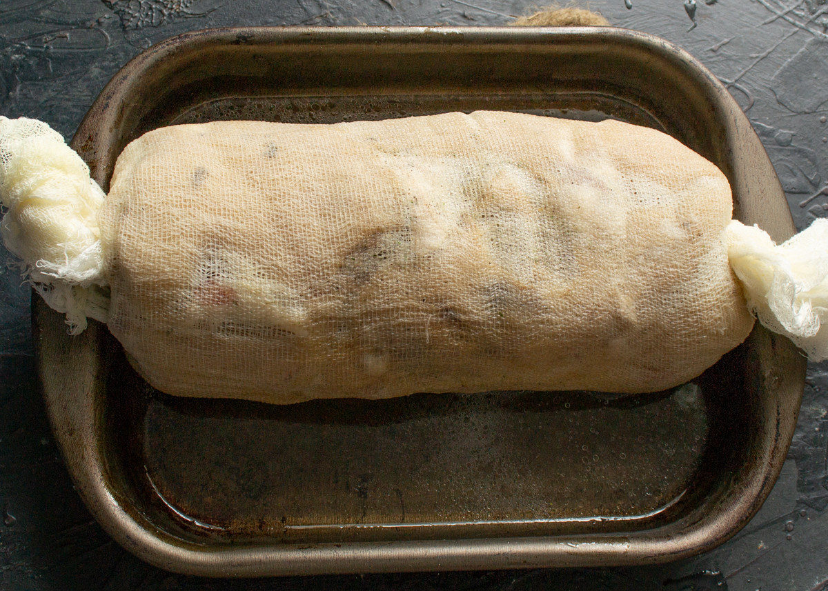 Заворачиваем мясо в марлю, поливаем рулет бульоном и убираем в холодильник на сутки